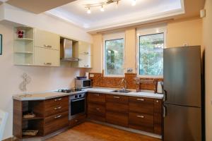 a kitchen with a stainless steel refrigerator and wooden cabinets at Blue Horizon Villa DV in Dobra Voda
