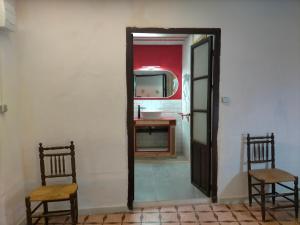 a bathroom with a mirror and two chairs and a sink at Casona Los Infantes in Villanueva de los Infantes