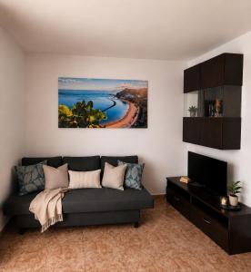 a living room with a couch and a tv at Perfectly located apartment with pool in Playa de las Americas