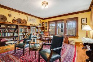 a library with chairs and a table and bookshelves at Prospect Hill on Main in Waynesville +20 photos