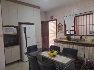 a kitchen with a table with a bowl of fruit on it at Recanto da praia in Bertioga