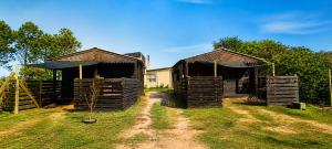two wooden huts with a swing in the grass at Cabañas CARPE DIEM Con o sin Jacuzzi in Barra del Chuy