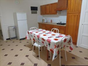 a kitchen with a table with a tablecloth on it at L'Annexe - Bis in Chalindrey