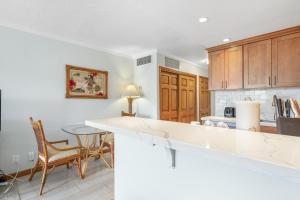 a kitchen with a counter and a table and chairs at Lahaina Shores #532 in Lahaina