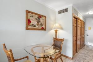 a dining room with a glass table and chairs at Lahaina Shores #532 in Lahaina