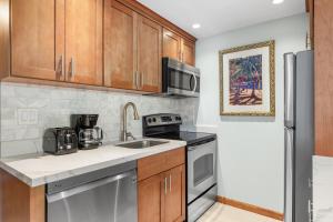 a kitchen with stainless steel appliances and wooden cabinets at Lahaina Shores #532 in Lahaina +16 photos