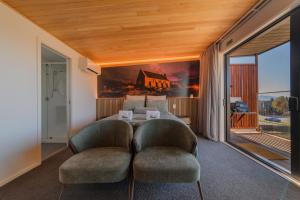 a hotel room with a bed and two chairs at Starlight Escape - Ohana in Lake Tekapo
