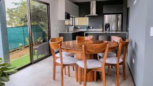 a kitchen with a wooden table and chairs at Casa Colibrí in Alajuela +20 photos