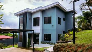 a modern house with a blue facade at Casa Colibrí in Alajuela