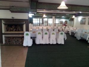 a banquet hall with white chairs and tables and a fireplace at Hotel Rimski Most in Sarajevo
