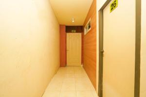 a hallway with a yellow door and a tile floor at Super OYO Naomi Heritage in Surabaya
