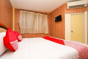 a bedroom with a bed with red pillows on it at Super OYO Naomi Heritage in Surabaya