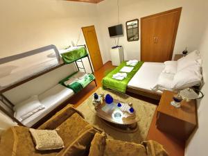 a room with two beds and a couch and a table at Grandpas House in Gjirokastër
