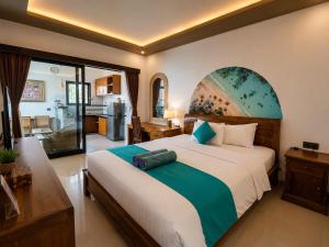 a bedroom with a large bed and a kitchen at Cahya Pandawa Villa in Nusa Dua +63 photos