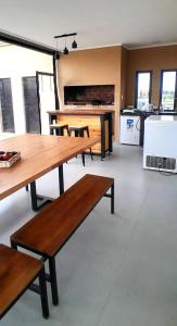 a room with wooden tables and a kitchen with windows at Glamping privado con pileta y quincho in San Vicente