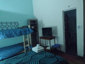 a room with two bunk beds and a desk with a computer at hotel tango club in Buenos Aires
