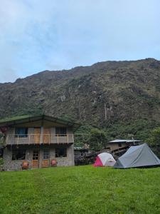 two tents in front of a building with a mountain at Salkantay Wasi in Colcapampa