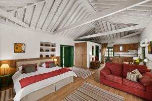 a bedroom with a large bed and a red couch at La Hacienda Grande in Puerto de la Cruz