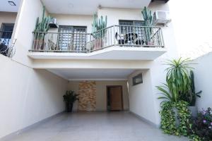 a white building with two balconies and potted plants at Pousada House Garden in Goiânia