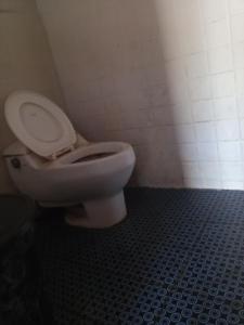 a bathroom with a white toilet in a room at Chepclean in Kelimutu