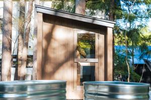 a small building with a window and two trash cans at Hakuba Bubu Chalet by Jade Villa in Hakuba