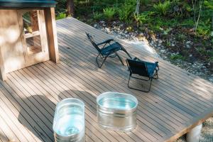 a wooden deck with two chairs and a bench on it at Hakuba Bubu Chalet by Jade Villa in Hakuba