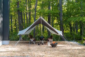 a large tent with two chairs and a grill at Hakuba Bubu Chalet by Jade Villa in Hakuba