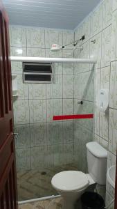 a bathroom with a toilet and a glass shower at Pousada Taiwan in Ubatuba
