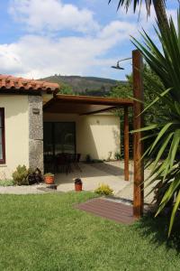 a patio of a house with a wooden pergola at Leiras da Cachada - Gerês in Valdosende