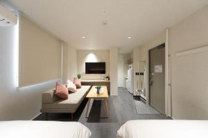a bedroom with a couch and a table in a room at MOMIJI TERRACE Hiroshima in Hiroshima