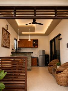 a kitchen and living room with a ceiling fan at Cahya Pandawa Villa in Nusa Dua