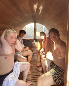 a group of young men sitting in a room at ログハウス1棟貸し,持込み自由,サウナ,露天風呂にバーべキュウや薪割り,ソーメン流しに収穫体験が楽しめます in Kashima