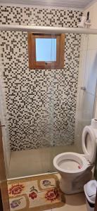 a bathroom with a shower with a toilet and a window at Casa de Temporada BR 470 in Cafundó