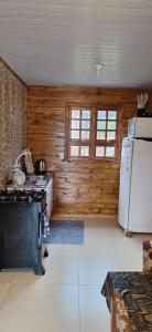 a kitchen with a stove and a refrigerator at Casa de Temporada BR 470 in Cafundó