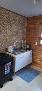a kitchen with a sink and a stove at Casa de Temporada BR 470 in Cafundó +4 photos