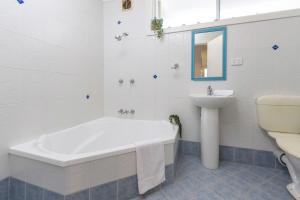 a bathroom with a tub and a sink and a toilet at Amaroo Cottage Smiths Lake in Smiths Lake +21 photos