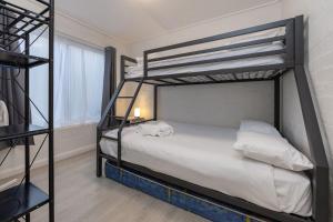 a bedroom with two bunk beds and a window at Amaroo Cottage Smiths Lake in Smiths Lake