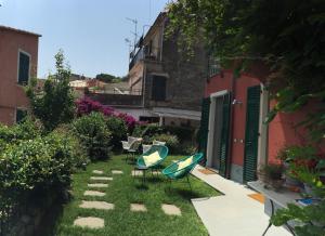 a garden with two chairs and a table and a building at La Casa di Andrea Relais in Monterosso al Mare