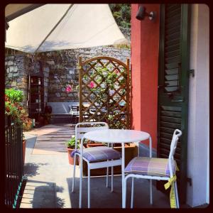 una mesa y sillas en un patio con un edificio en La Casa di Andrea Relais, en Monterosso al Mare