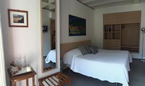 a bedroom with a white bed and a mirror at La Casa di Andrea Relais in Monterosso al Mare