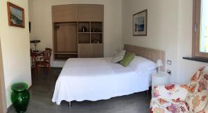 a bedroom with a large white bed and a chair at La Casa di Andrea Relais in Monterosso al Mare