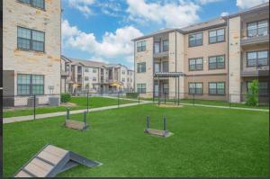 an apartment complex with a playground in front of a building at Humble cozy home in Humble