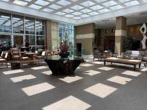 a lobby with a table and chairs in a building at Apartamento Jade Hotel - Park Sul in Brasília