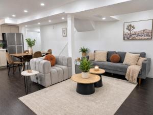 a living room with two couches and a table at Chic & Spacious 2BR Home Near Yonge St in Newmarket