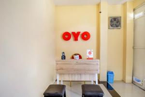 a room with two stools and a red sign on the wall at Hotel O Sofia Homestay Syariah in Bogor