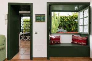 a room with a window and a bench with pillows at La Hacienda Grande in Puerto de la Cruz