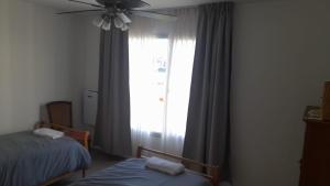 a bedroom with two beds and a large window at Ecos de mar in Mar del Sur