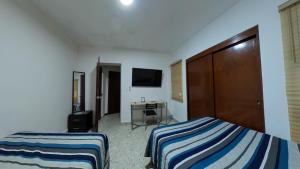 a hotel room with two beds and a desk at JESAVI Leones in Monterrey