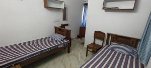 a bedroom with two beds and a mirror at Santha Residency in Ambātturai