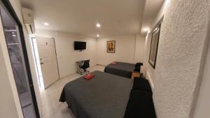 a small room with a bed and a tv at JESAVI Leones in Monterrey